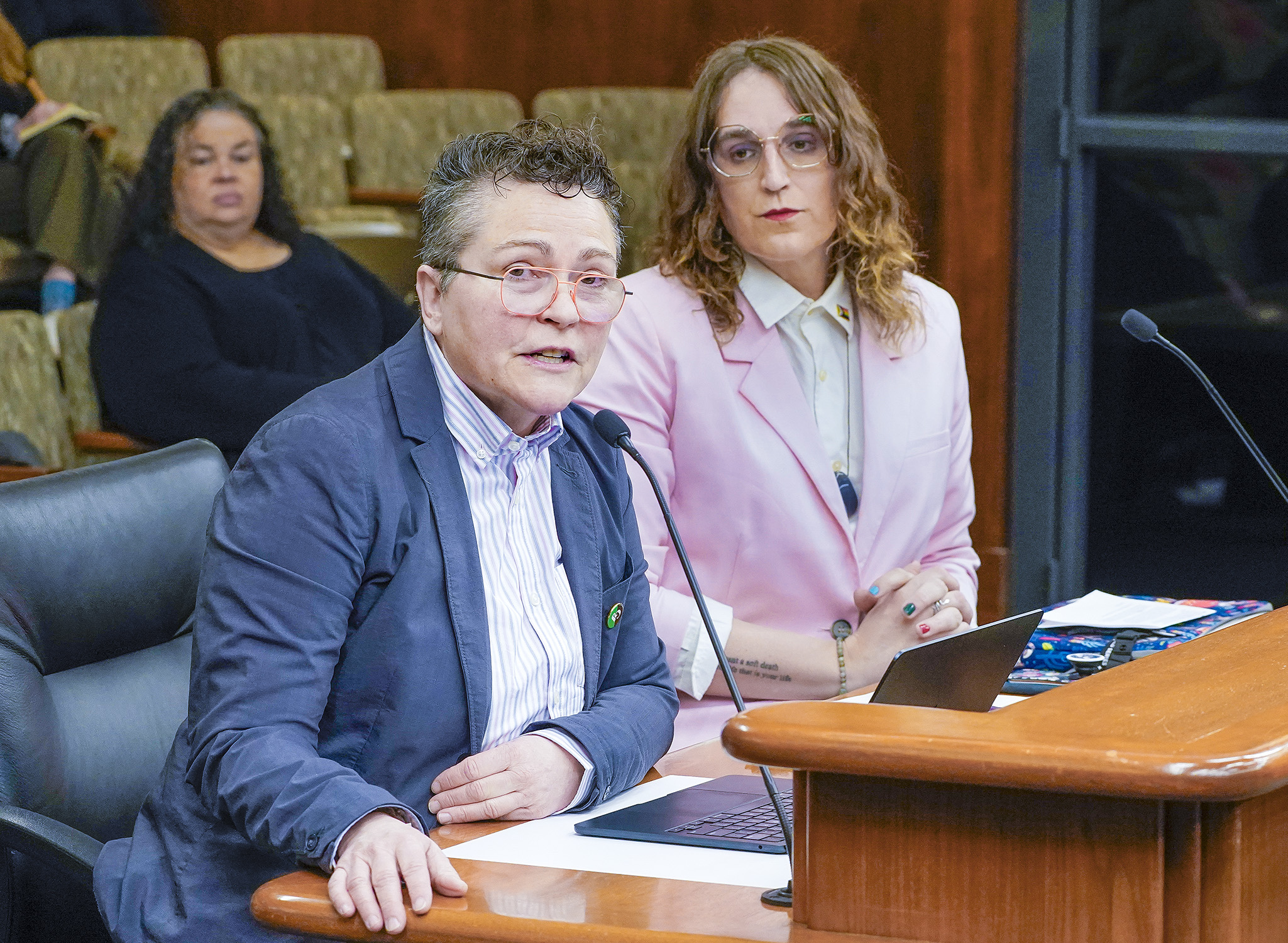 Monica Meyer, political director at Gender Justice, testifies before the House's local government committee in support of a bill sponsored by Rep. Leigh Finke, right, to prohibit banning the display of items containing a rainbow. (Photo by Andrew VonBank)
